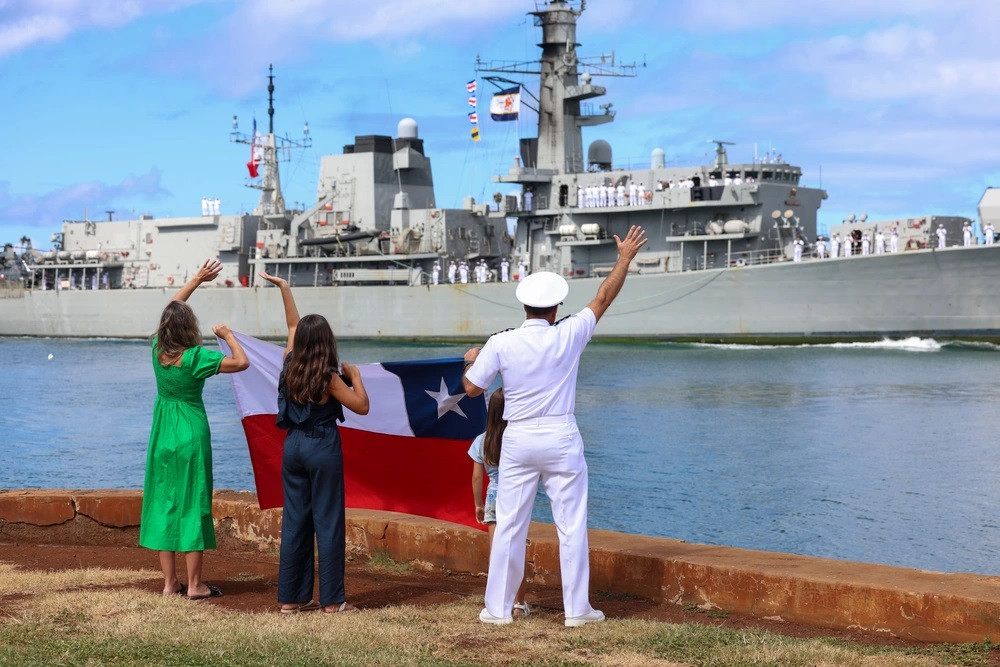 El capitán de navío Jorge Vergara saluda con la bandera chilena a la tripulación de la fragata FF 06 Almirante Condell a su arribo a Hawaii Firma Mass Communication Specialist 2nd Class Courtney Strahan US Navy