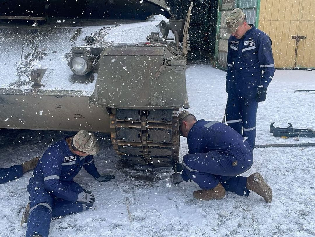 Alumnos del curso de conductor de tanque Leopard 1V efectuando revisiu00f3n en cojinetes de oruga Firma Escuela de Caballeru00eda Blindada del Eju00e9rcito de Chile