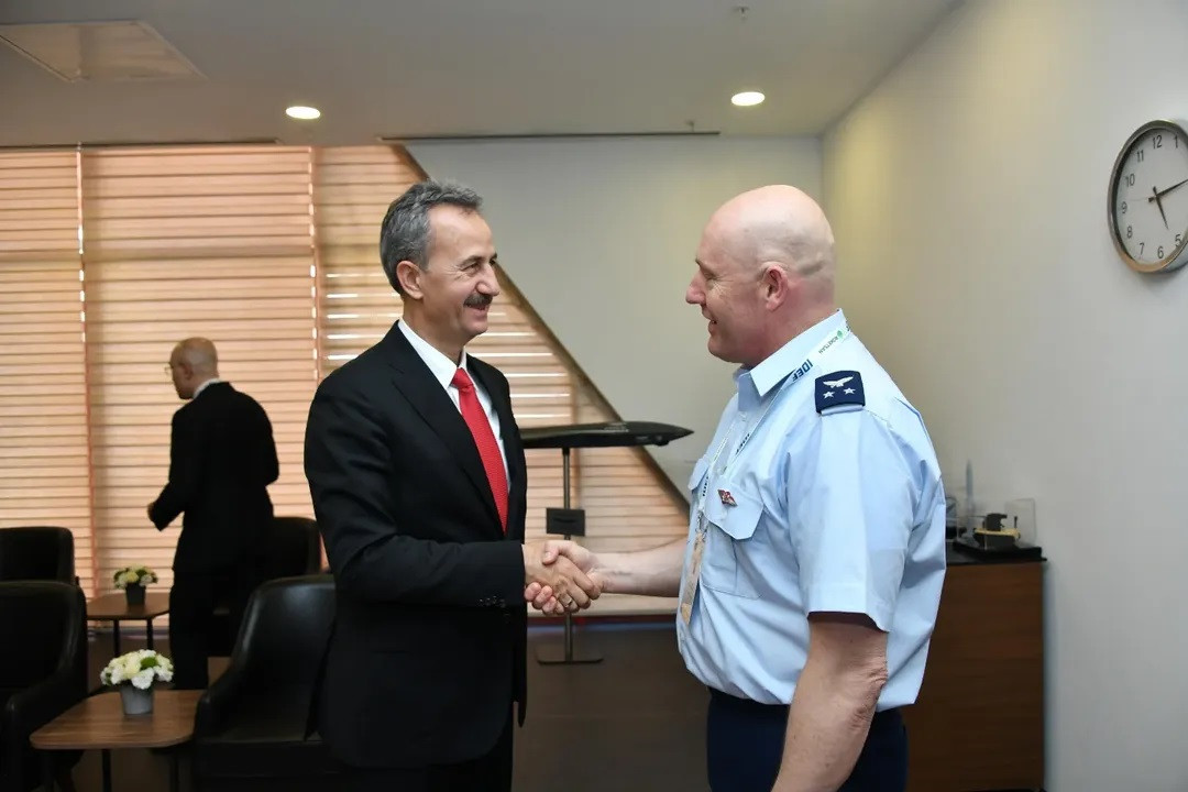 Haluk Görgün saluda al director de Planificación Conjunta del Estado Mayor Conjunto de Chile, firma Savunma Sanayii Başkanlığı.