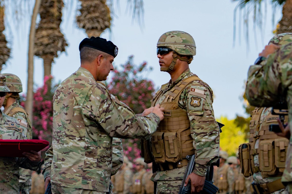 El coronel Cristian Lauriani entrega una condecoraciu00f3n por au00f1os de servicio a un integrante de la Brigada Motorizada Nu00b04 Rancagua Firma Gobierno Regional de Arica y Parinacota